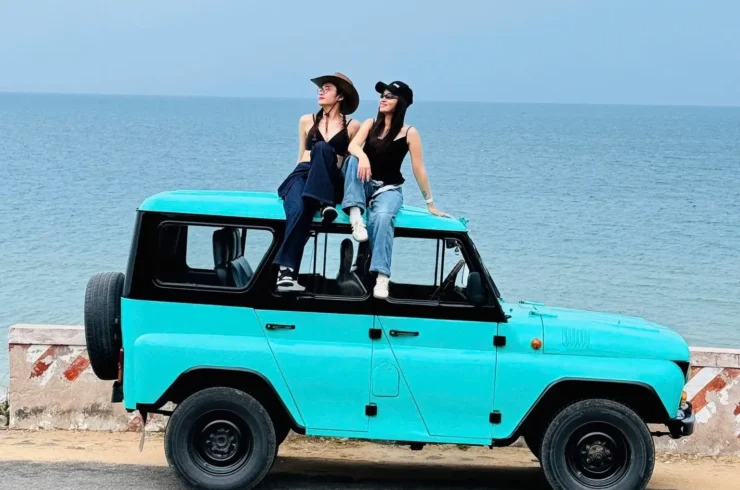 Xe jeep địa hình đang chạy trên triền cát trắng ở Bàu Trắng, một bối cảnh team building ấn tượng kết hợp giữa sa mạc và hồ nước tại Bình Thuận